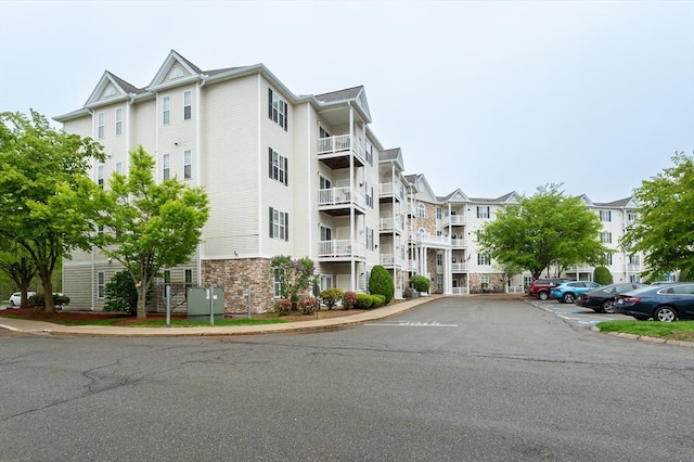 view of apartment building / complex featuring uncovered parking
