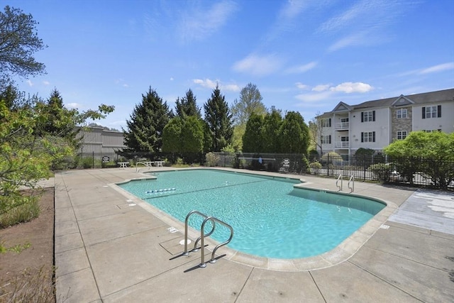 community pool with fence and a patio area