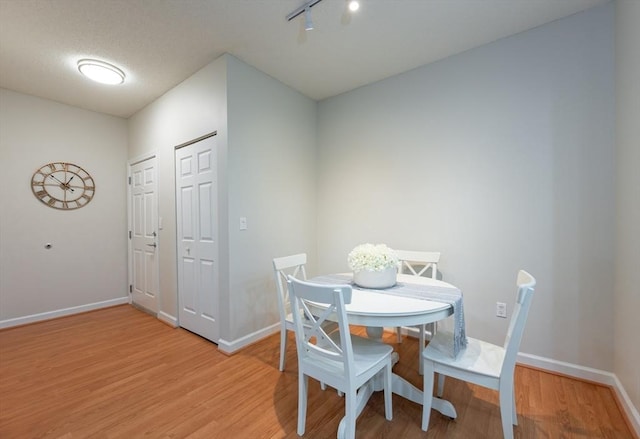 dining area featuring light wood-type flooring and baseboards