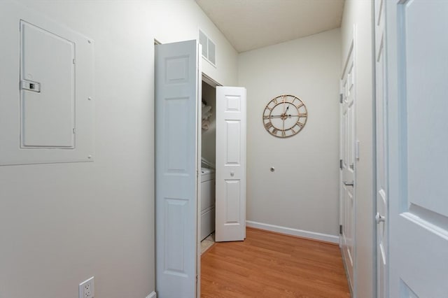 hall with electric panel, light wood-style flooring, and baseboards