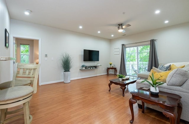 living room featuring light wood-style floors, a ceiling fan, healthy amount of natural light, recessed lighting, and baseboards