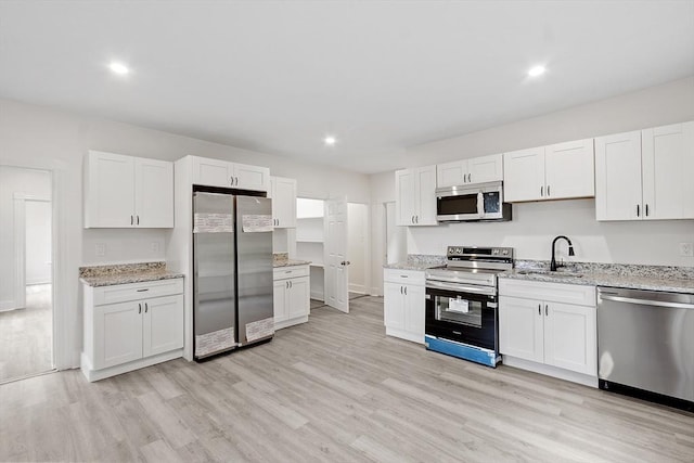 551 Chestnut St, Athol, MA 01331 - kitchen featuring stainless steel appliances, light wood-style floors, white cabinetry, light stone countertops, and recessed lighting