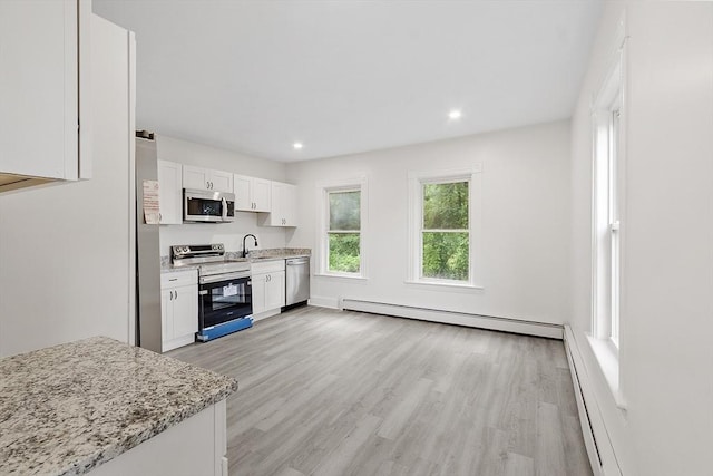 551 Chestnut St, Athol, MA 01331 - kitchen featuring appliances with stainless steel finishes, a baseboard radiator, white cabinetry, light wood-type flooring, and light stone countertops