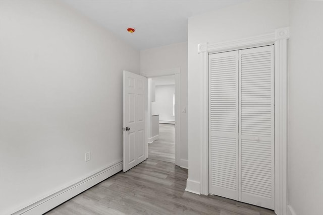 551 Chestnut St, Athol, MA 01331 - unfurnished bedroom featuring a baseboard heating unit, wood finished floors, and a closet