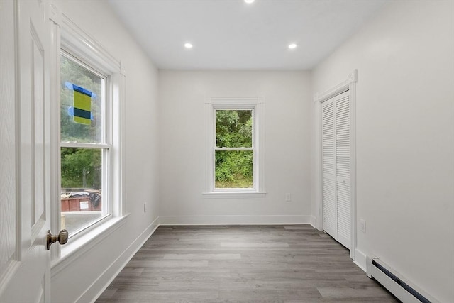 551 Chestnut St, Athol, MA 01331 - unfurnished bedroom with baseboard heating, wood finished floors, a closet, and recessed lighting
