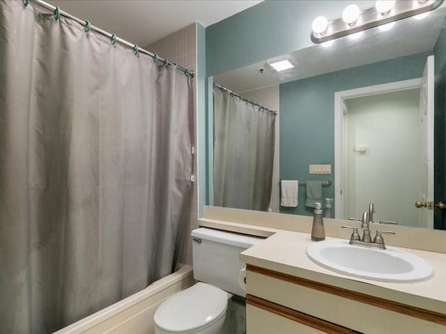 full bathroom with shower / bath combination with curtain, vanity, and toilet