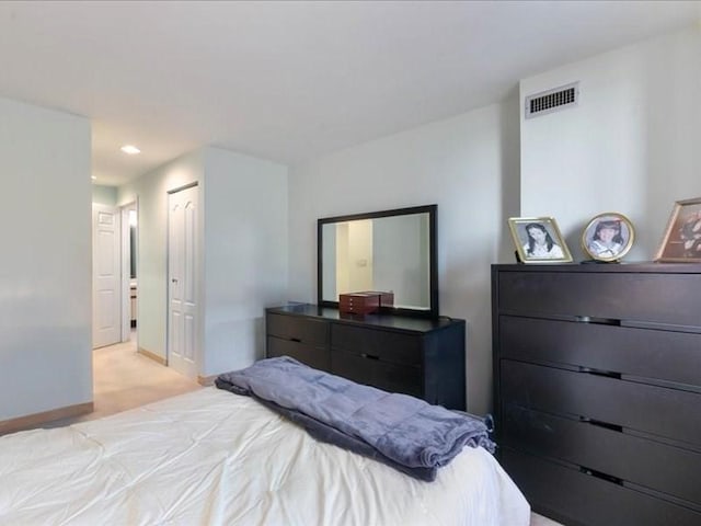 bedroom featuring light carpet and a closet