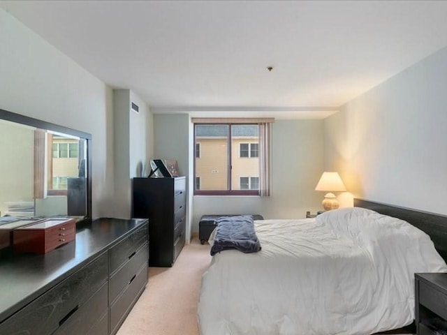 bedroom with multiple windows and light colored carpet