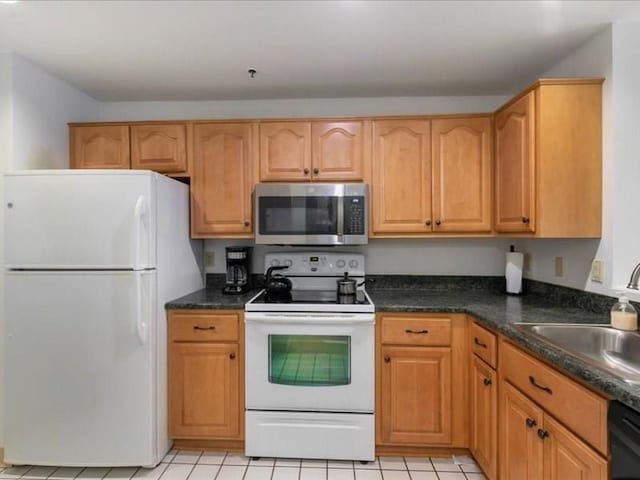 kitchen with white appliances, sink, and dark stone counters