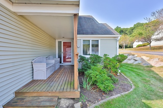 entrance to property with a wooden deck and a yard