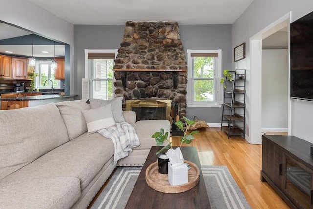 38 Colonial Rd, Weymouth, MA 02191 - living room with plenty of natural light, light wood-type flooring, baseboards, and a stone fireplace