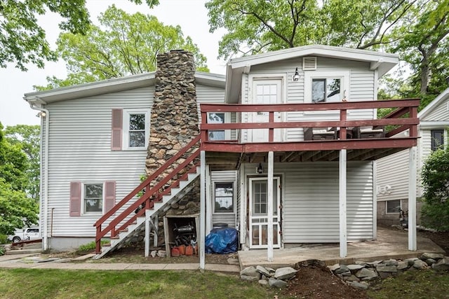 38 Colonial Rd, Weymouth, MA 02191 - back of property with a deck, stairway, and a chimney
