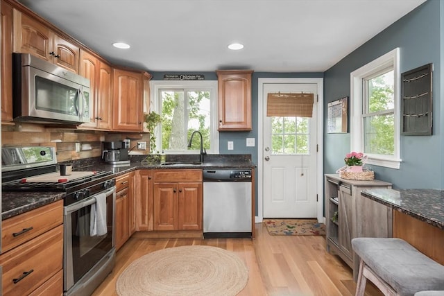 38 Colonial Rd, Weymouth, MA 02191 - kitchen with appliances with stainless steel finishes, a sink, light wood finished floors, dark stone countertops, and decorative backsplash