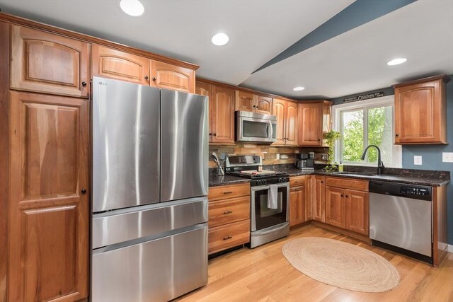 38 Colonial Rd, Weymouth, MA 02191 - kitchen featuring stainless steel appliances, vaulted ceiling, a sink, dark stone countertops, and light wood-type flooring