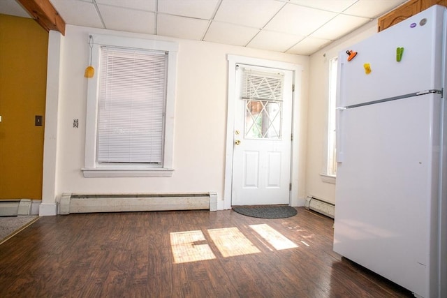 doorway with baseboard heating, wood finished floors, a drop ceiling, and a baseboard heating unit
