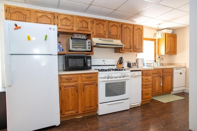 kitchen featuring white appliances, under cabinet range hood, light countertops, and dark wood-style floors
