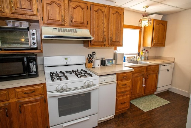 kitchen featuring white appliances, range hood, a sink, dark wood-type flooring, and light countertops