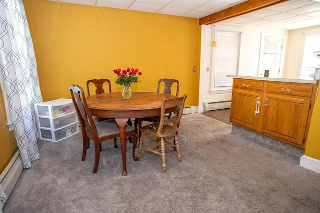 dining room with a baseboard heating unit, carpet flooring, and a paneled ceiling