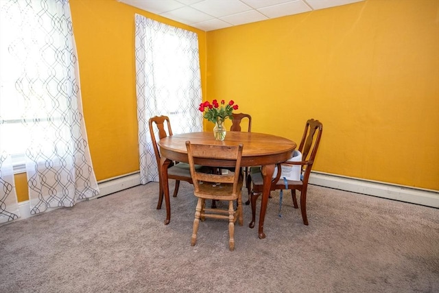 carpeted dining room featuring baseboard heating, a paneled ceiling, and baseboards