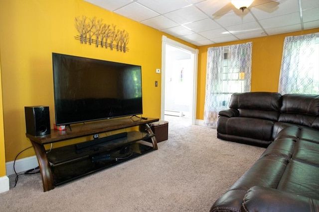 living room featuring carpet flooring, a ceiling fan, a baseboard radiator, a drop ceiling, and baseboards