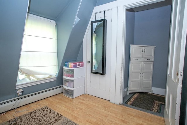 bonus room with a baseboard radiator and wood finished floors