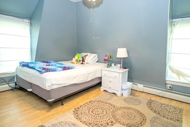 bedroom featuring wood finished floors and a baseboard radiator