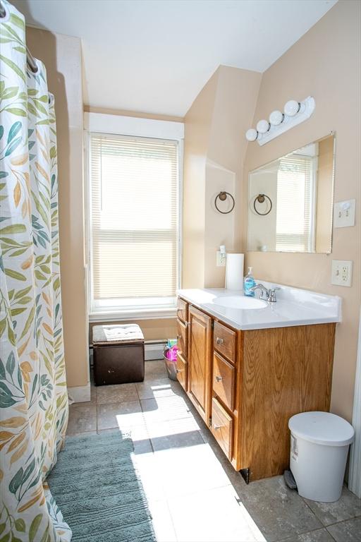 full bathroom featuring vanity, a baseboard radiator, and tile patterned flooring