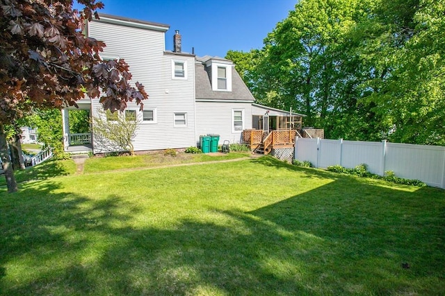 rear view of property featuring a wooden deck, a chimney, and a shingled roof