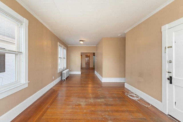 corridor featuring hardwood / wood-style floors, ornamental molding, and radiator