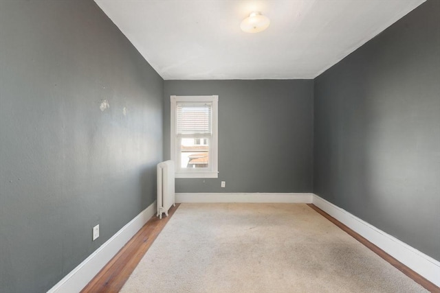 unfurnished room with light wood-type flooring and radiator