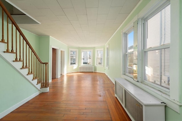 interior space featuring radiator heating unit, a healthy amount of sunlight, and hardwood / wood-style floors