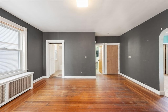 spare room with wood-type flooring and radiator heating unit