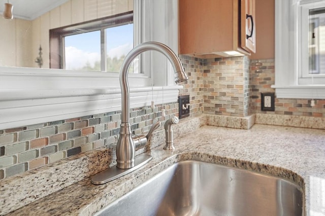 details with light stone countertops, sink, and decorative backsplash