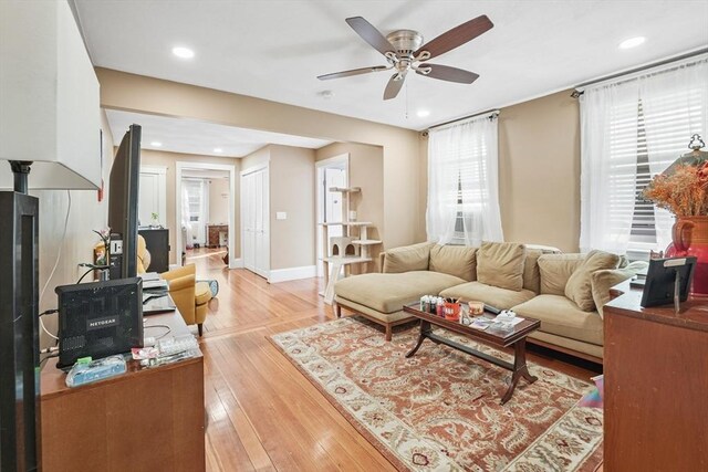 living room with light hardwood / wood-style flooring and ceiling fan