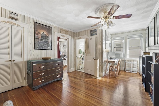 miscellaneous room with dark hardwood / wood-style flooring, wooden walls, ornamental molding, and ceiling fan