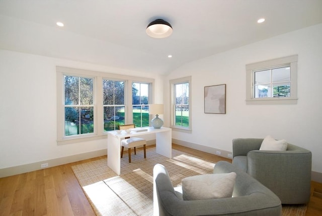 sitting room featuring light wood-type flooring and vaulted ceiling