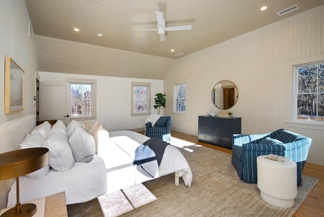 bedroom with ceiling fan, light hardwood / wood-style floors, and vaulted ceiling