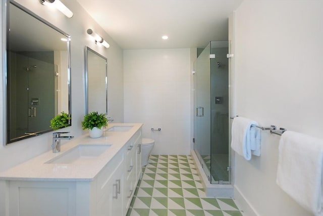 bathroom with vanity, toilet, and a shower with shower door