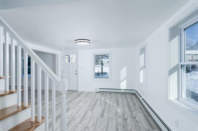 foyer featuring baseboard heating and light wood-type flooring