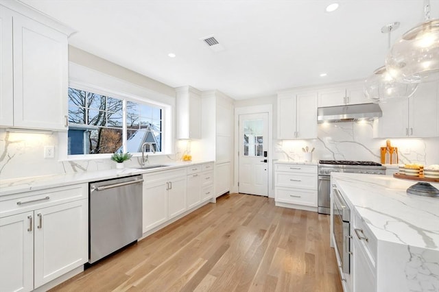 kitchen with backsplash, white cabinetry, and appliances with stainless steel finishes