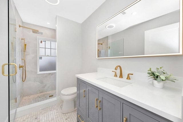 bathroom featuring toilet, vanity, tile patterned floors, and a shower with shower door