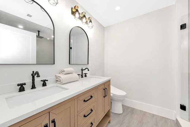 bathroom with walk in shower, hardwood / wood-style flooring, vanity, and toilet