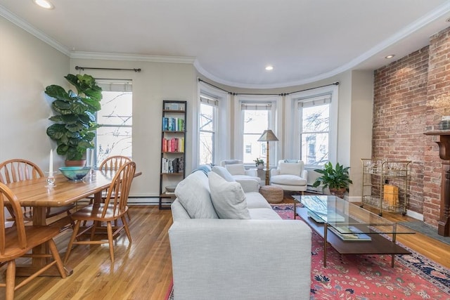 living room with crown molding, a healthy amount of sunlight, a fireplace, and light wood-type flooring