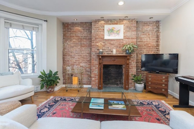 living room featuring wood-type flooring, a brick fireplace, and a healthy amount of sunlight