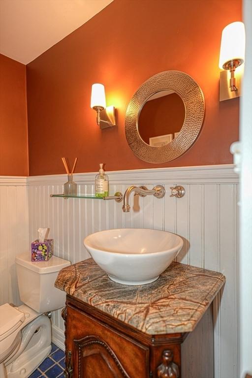 bathroom with wainscoting, toilet, and vanity