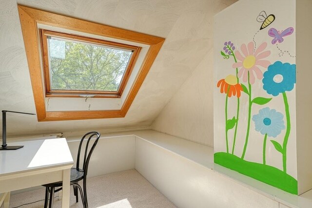 unfurnished office featuring carpet floors, lofted ceiling, and a skylight