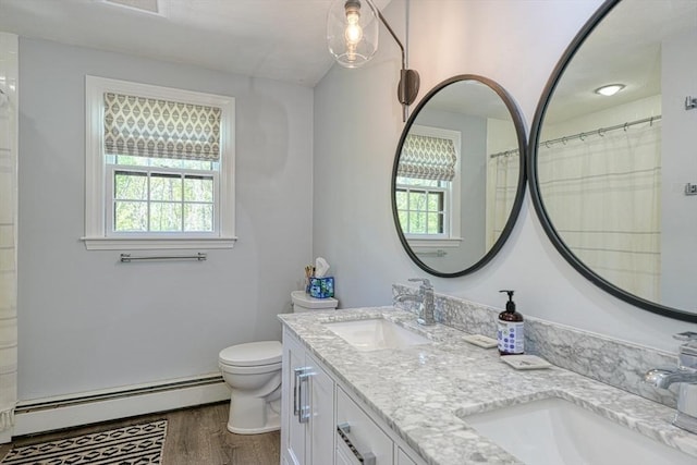 full bathroom featuring a baseboard heating unit, plenty of natural light, wood finished floors, and toilet