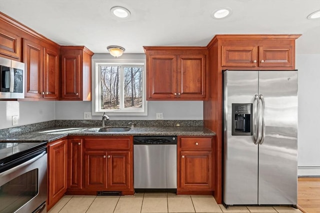 kitchen with a sink, stainless steel appliances, recessed lighting, and a baseboard radiator