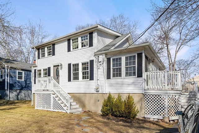 view of front facade featuring stairway, a deck, and a front lawn