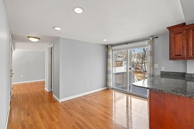 unfurnished dining area with recessed lighting, baseboards, and light wood-type flooring